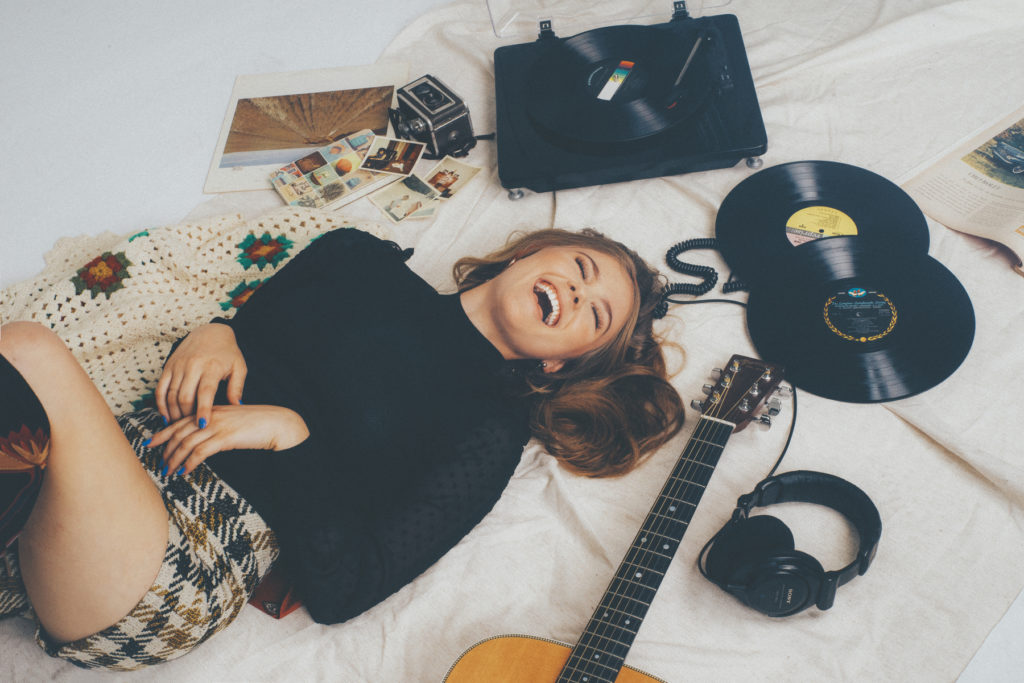 Kerri Medders laughing in a 60's inspired photo shoot Vinyl Records vintage Polaroids Record player Martin acoustic guitar